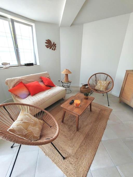 un salon avec un canapé et deux chaises dans l'établissement magnifique appartement neuf, à Royan