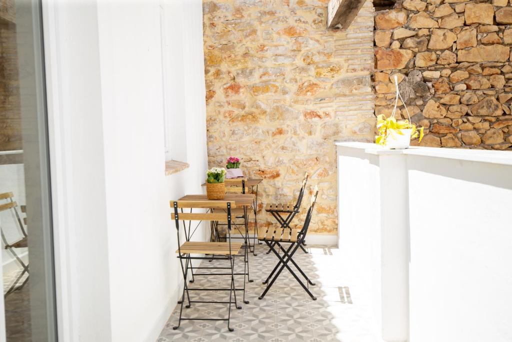a table and chairs in a room with a stone wall at Colón 29 Apartments in Denia