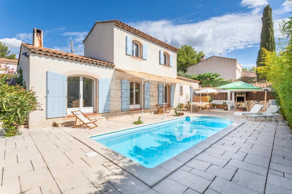 una villa con piscina frente a una casa en Villa Azul - Welkeys, en Bandol