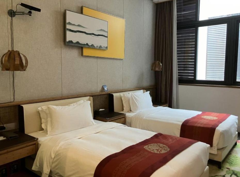 Postel nebo postele na pokoji v ubytování Nanxianglou Art Hotel