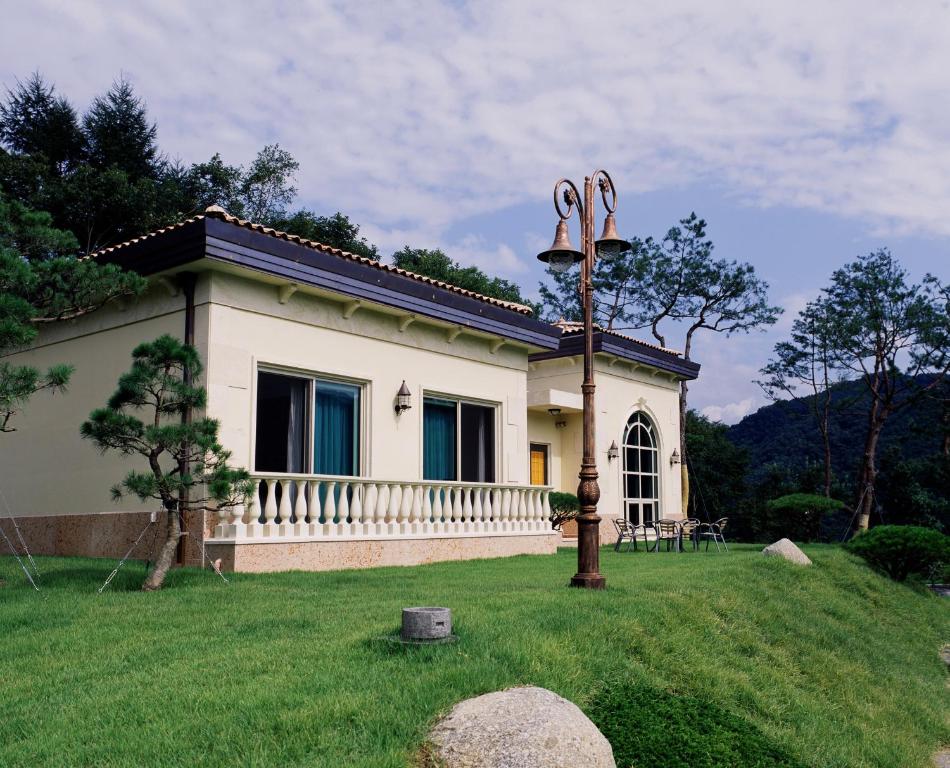 Crystal Valley CC Golden Village في كابيونغ: منزل صغير في حقل مع ساحة عشبية