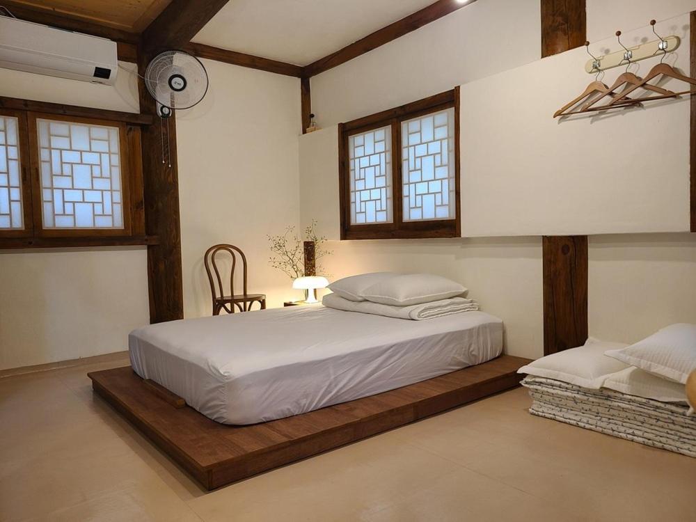 a bedroom with a bed in a room with windows at Yeongam Haeden Hanok Stay in Yeongam