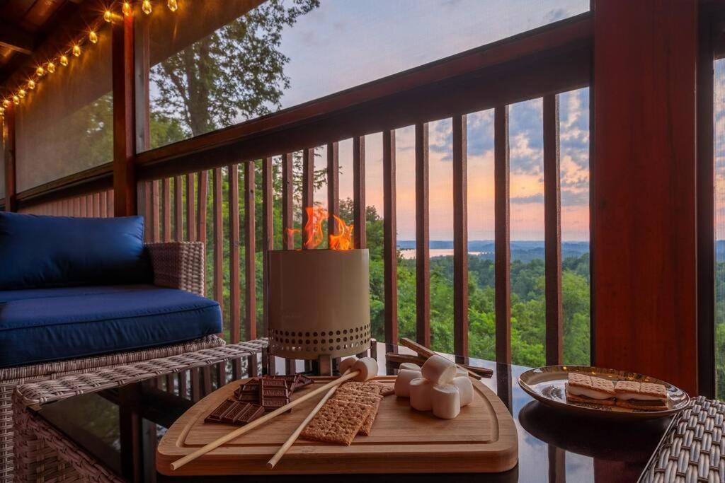 a balcony with a table and a couch on a porch at Incredible Views l Family Friendly I Pool - Hot Tub in Sevierville