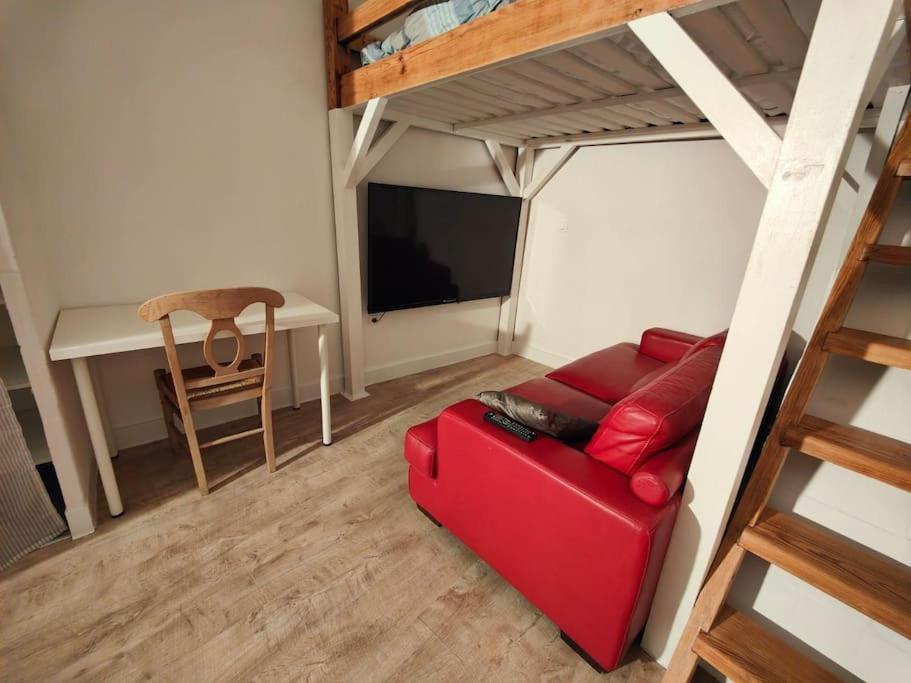 - un salon avec un canapé rouge et un bureau dans l'établissement Studio rénové centre-ville Nîmes, à Nîmes