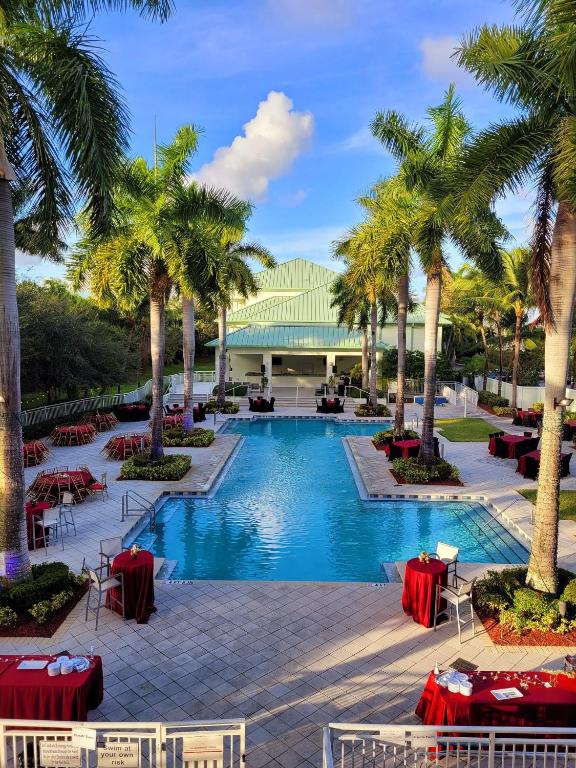 a pool at the resort with palm trees and tables at Doral Pool 310 by WaveProperties in Miami
