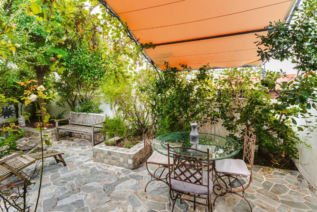 un patio avec une table, des chaises et des arbres dans l'établissement Maison coeur de ville chez Diego, à La Rochelle