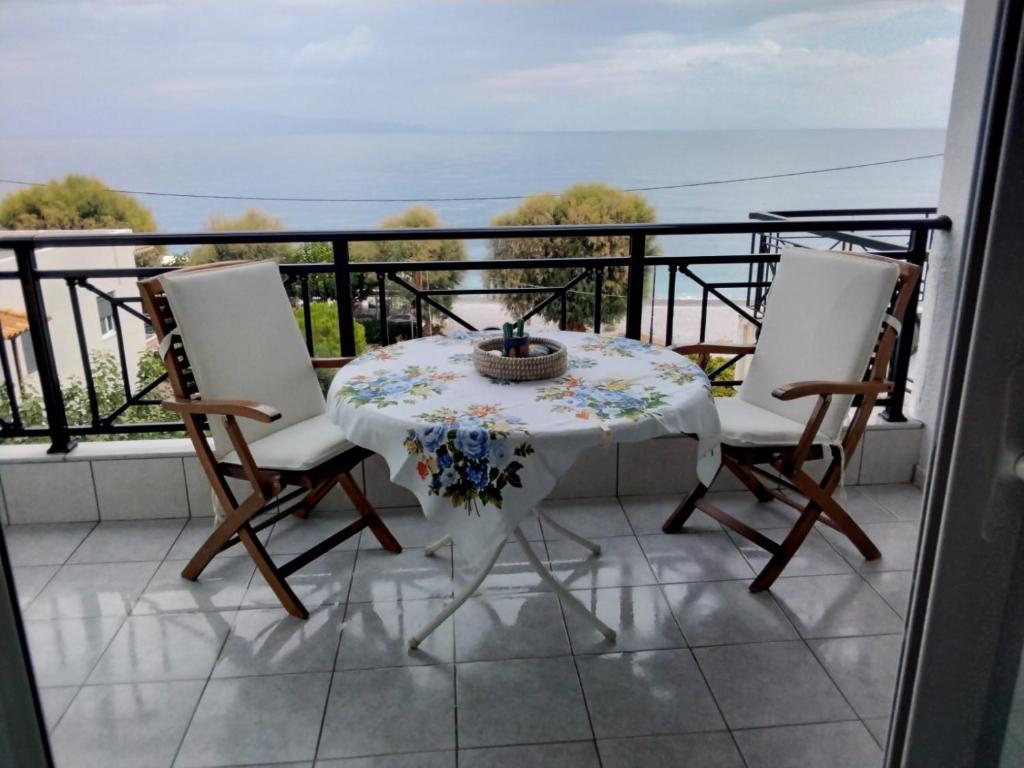 a table and chairs on a balcony with a view of the ocean at Anastasia in Paralía Akrátas