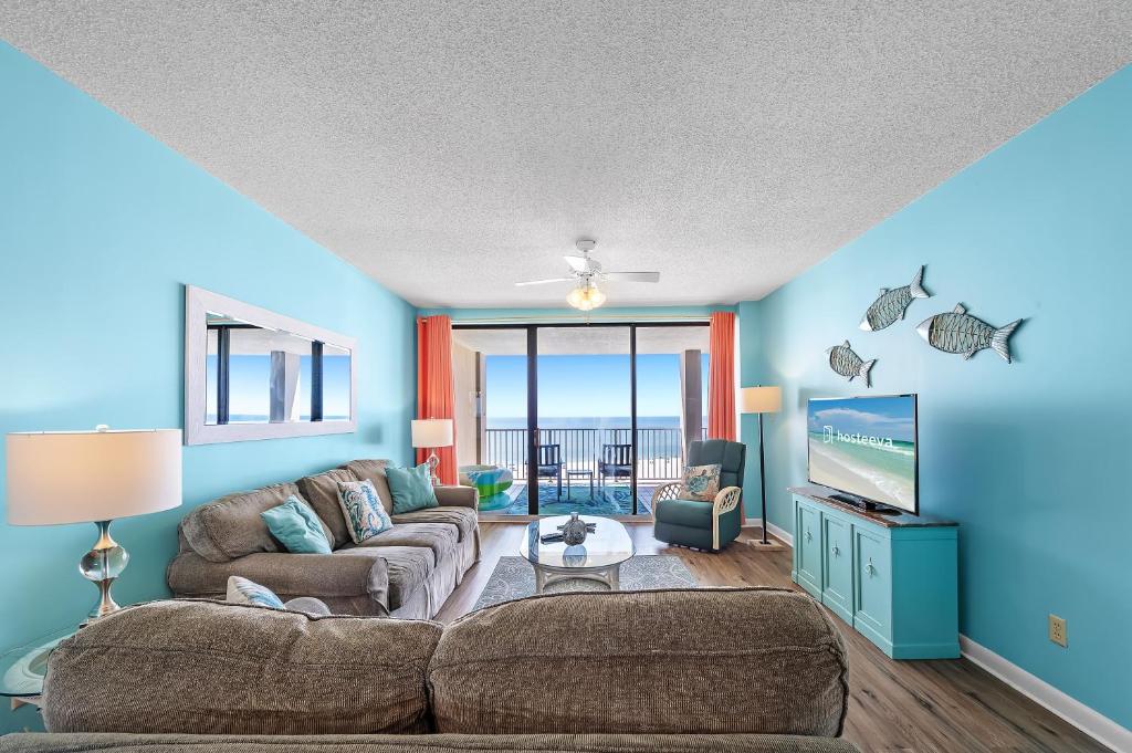 a living room with a couch and a tv at White Caps Condos in Orange Beach