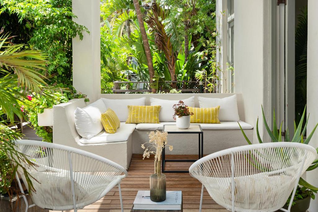 une terrasse avec un canapé blanc et 2 chaises dans l'établissement Neighbourgood Romney, au Cap