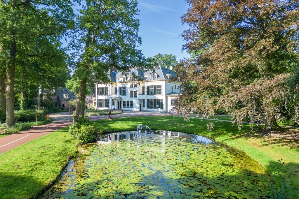 een landgoed met een vijver voor een huis bij Landgoed de Horst in Driebergen