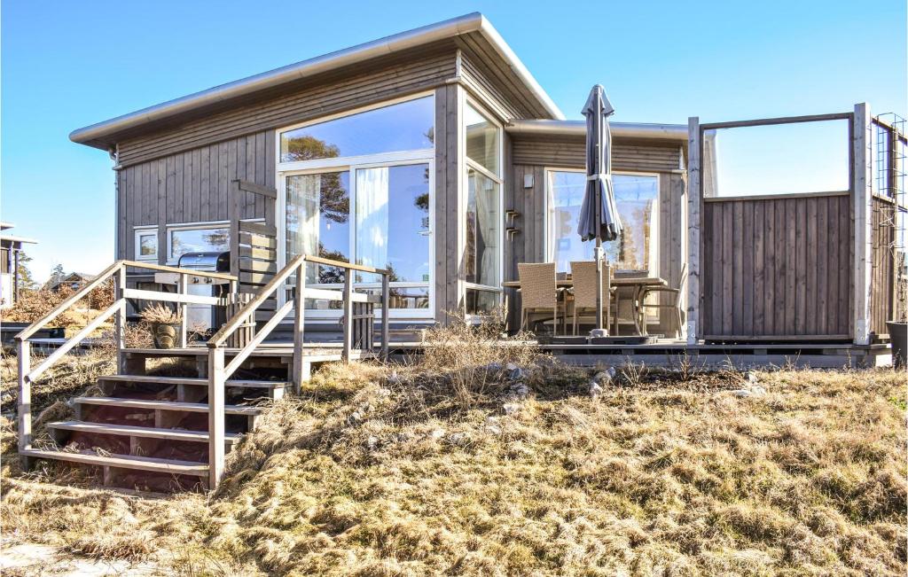 a wooden house with glass doors and a deck at Nice Home In Manstad With Kitchen in Saltnes