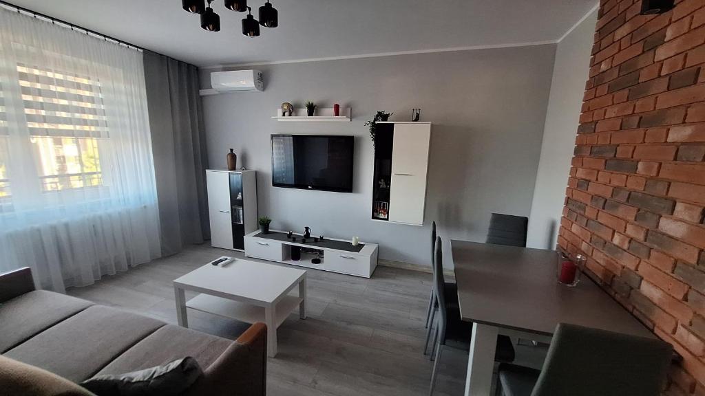 una sala de estar con un sofá y una mesa en Magmares Apartment, en Bydgoszcz