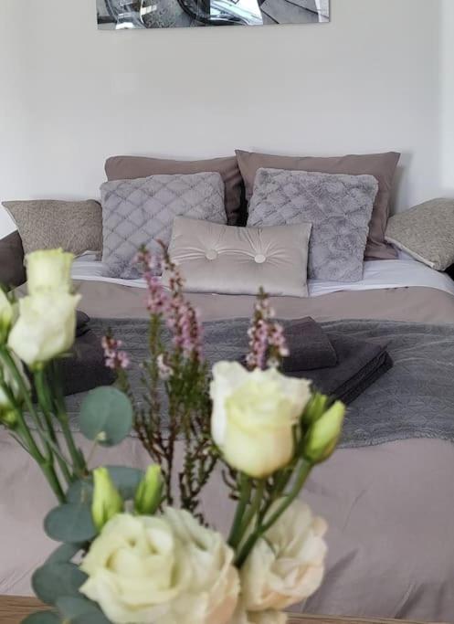 - un salon avec un canapé et un vase de fleurs dans l'établissement Agréable studio avec cour à 10mn de Fontainebleau, à Héricy