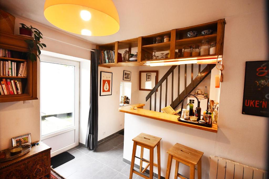 a living room with a staircase and two stools at la petite maison pour deux in Cité de Beauregard