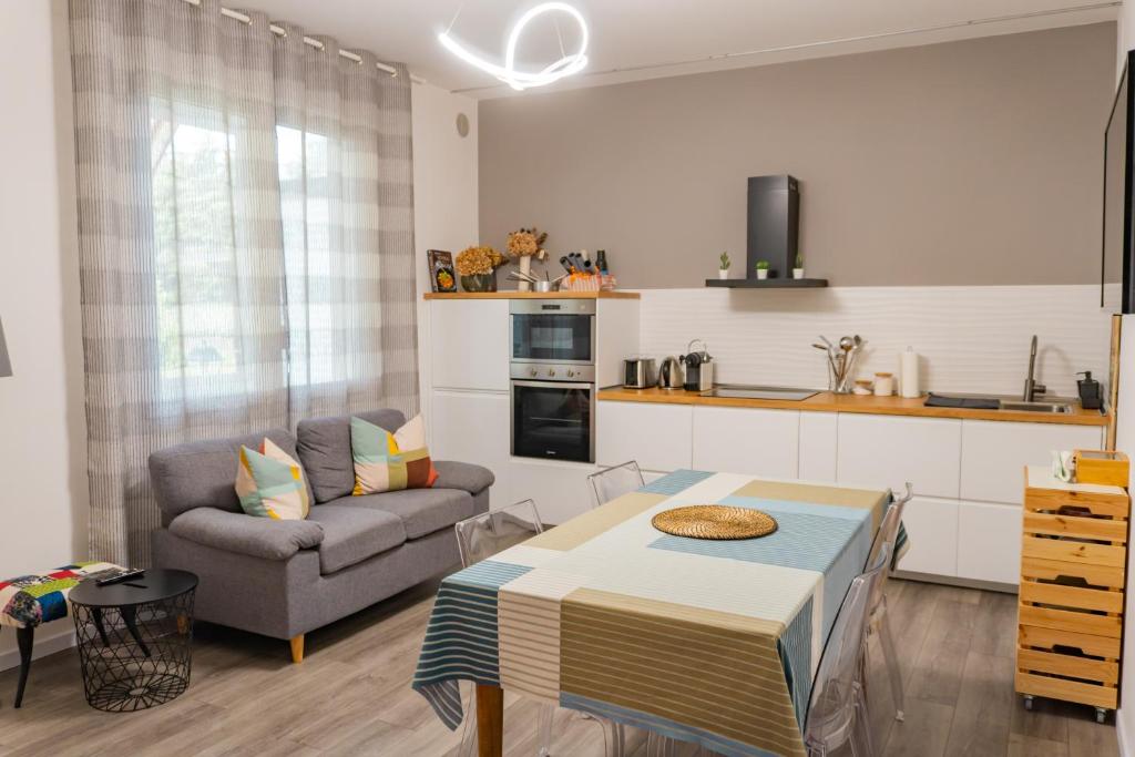 a living room with a couch a table and a kitchen at Casa Mirella in Cavallino-Treporti