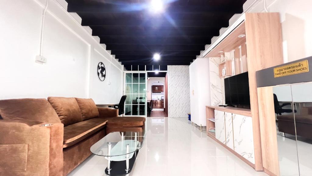 Una sala de estar con un sofá y una mesa de cristal. en uouRangnamHouse, en Bangkok