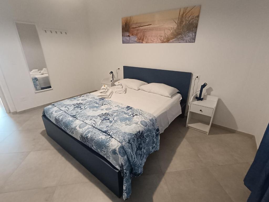 Un dormitorio con una cama con una manta azul y blanca. en Le Cale Apartment, en Livorno