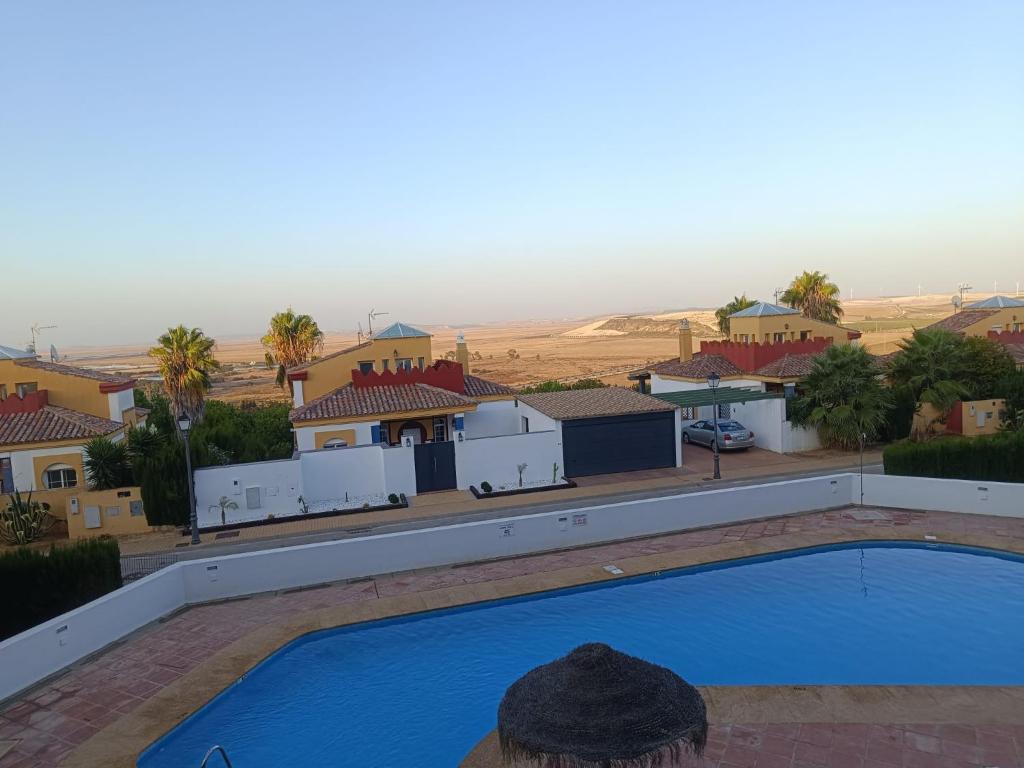 a person is standing next to a blue swimming pool at Mirador de los Navegantes in Sanlúcar de Barrameda