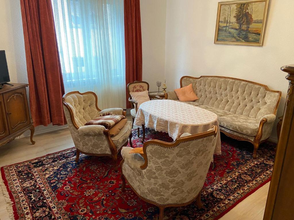 uma sala de estar com um sofá, cadeiras e uma mesa em Monteurswohnung, Ferienwohnung em Zella-Mehlis