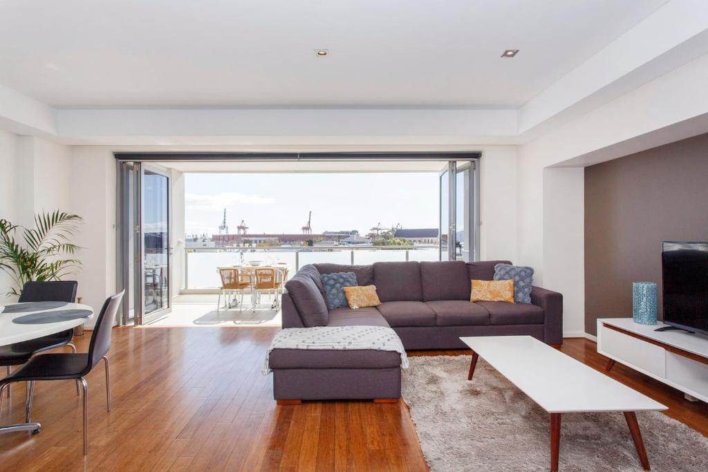 a living room with a couch and a table at Gallery On High Pool, Port Views & Free Park in Fremantle