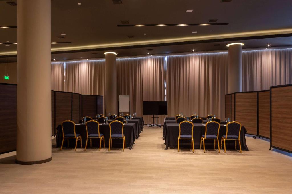 uma sala de conferências com cadeiras e um pódio em Tryp by Wyndham Asuncion em Assunção