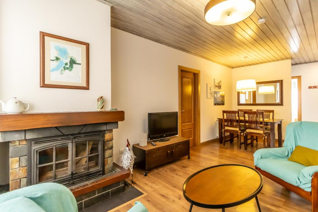 un salon avec une cheminée et une télévision dans l'établissement Apartamento San Fabian de Bossost, à Bossost