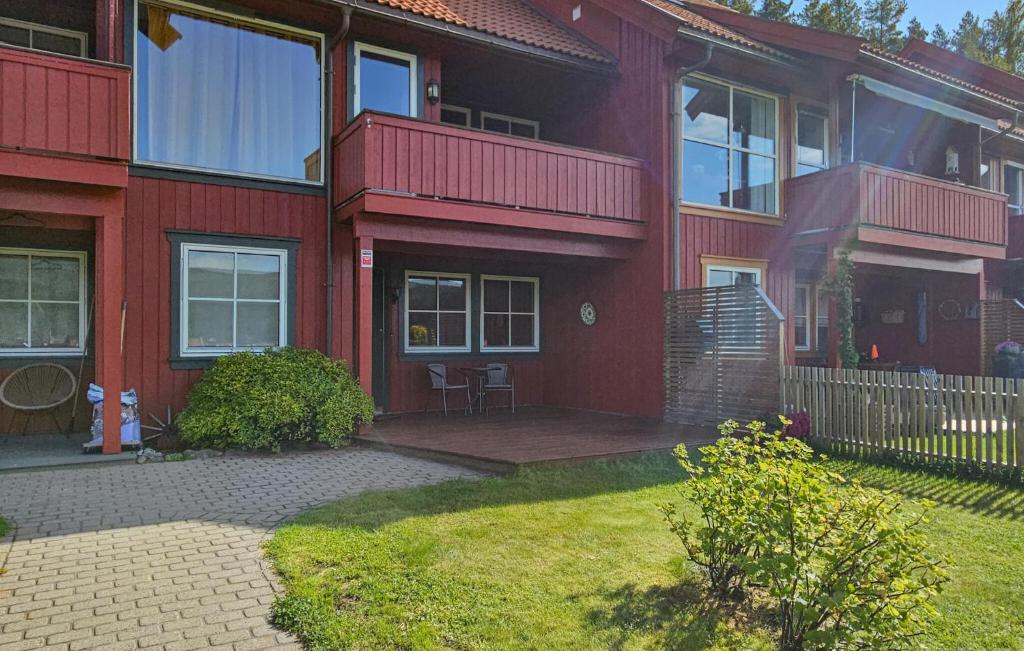a red house with a patio and a yard at Cozy Home In Kongsberg in Kongsberg