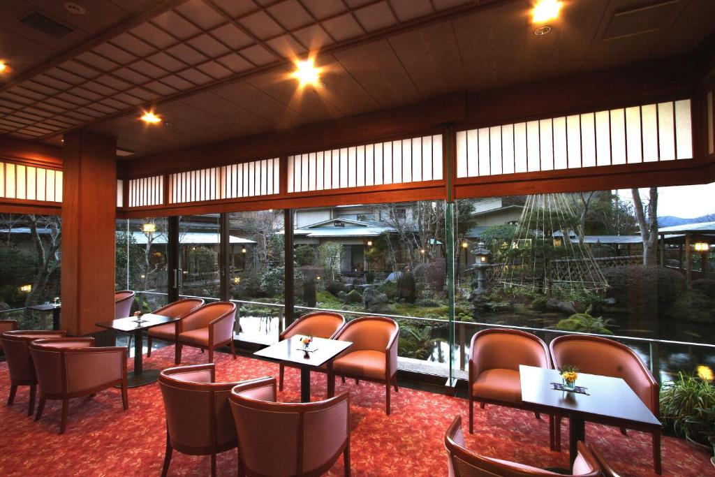 a restaurant with tables and chairs and large windows at Yoshimatsu in Hakone