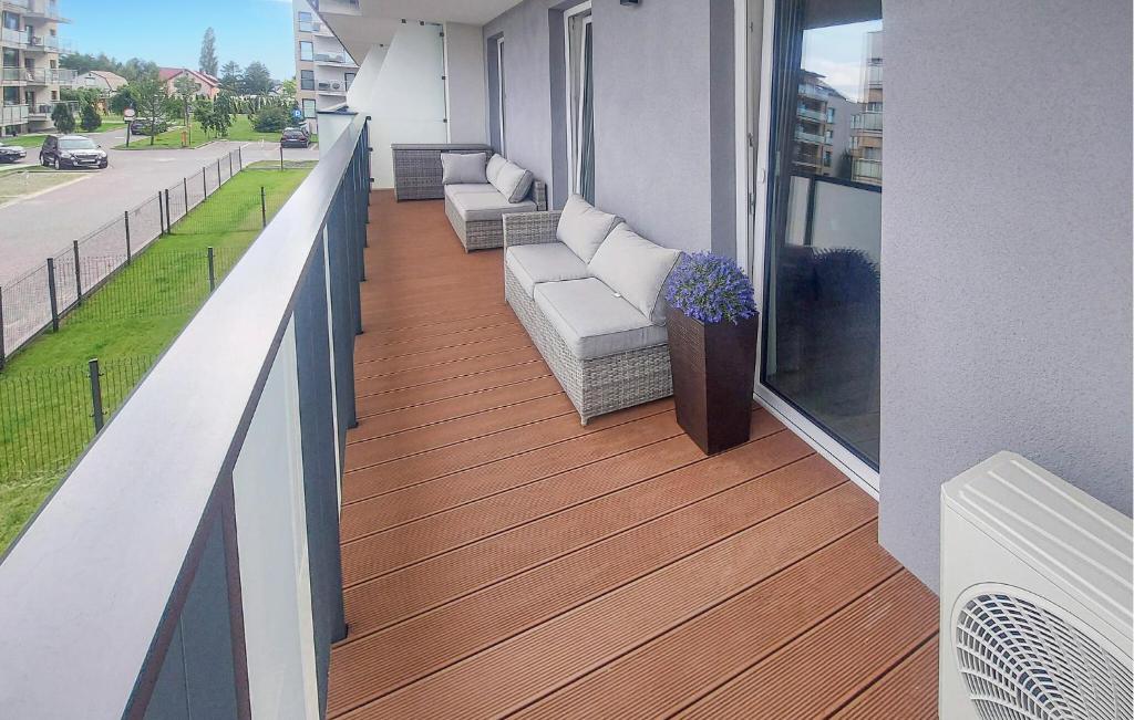 Un balcón con sofás y sillas en un edificio. en Gorgeous Apartment In Sianozety, en Sianożęty