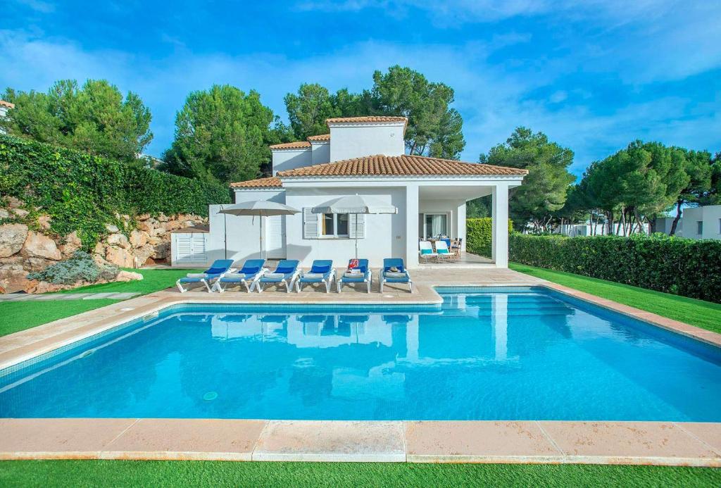 una villa con piscina frente a una casa en San Francisco by Vintage Travel, en Arenal d'en Castell