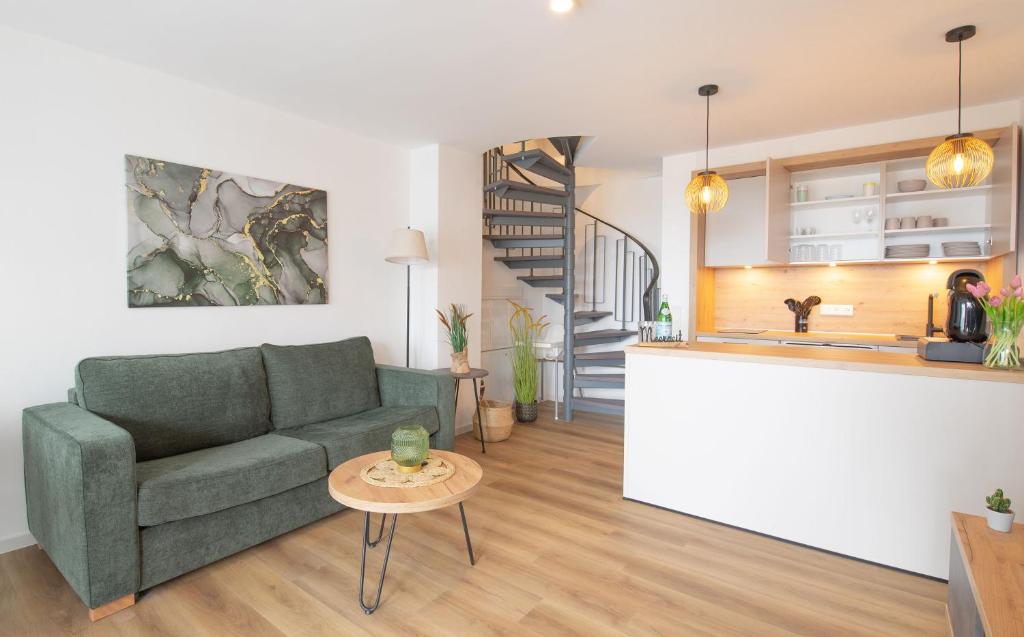 Küstenrose في كاروليننسيل: غرفة معيشة ومطبخ مع أريكة وطاولة