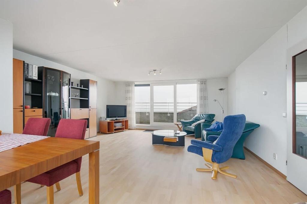 a living room with a table and some chairs at Hello Zeeland - Appartement Port Scaldis 13-112 in Breskens