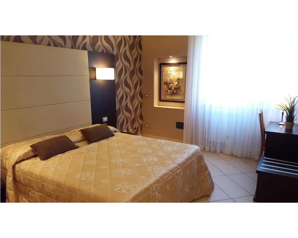 1 dormitorio con cama, escritorio y ventana en B&B Emozioni Romane, en Roma
