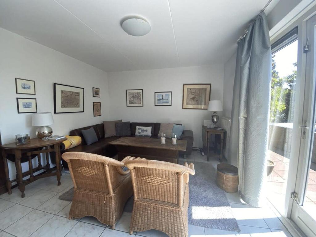 a living room with a couch and a table and chairs at Hello Zeeland - Vakantiehuis Zwin 092 in Breskens