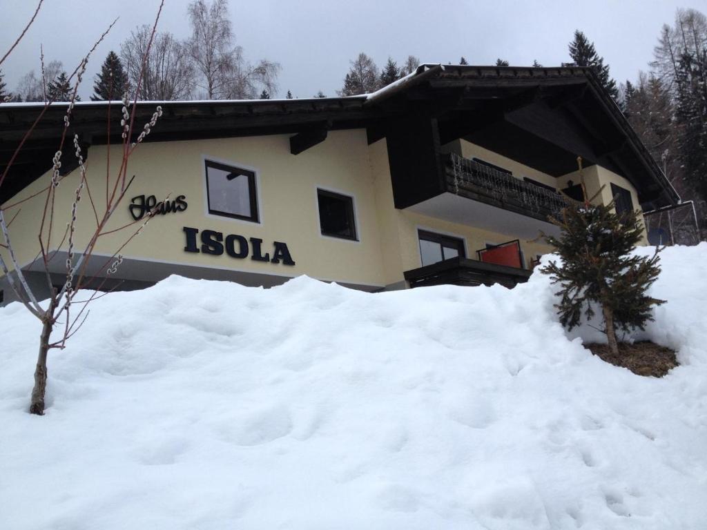 un edificio con un montón de nieve delante de él en Appartements ISOLA Bad Kleinkirchheim, en Untertschern