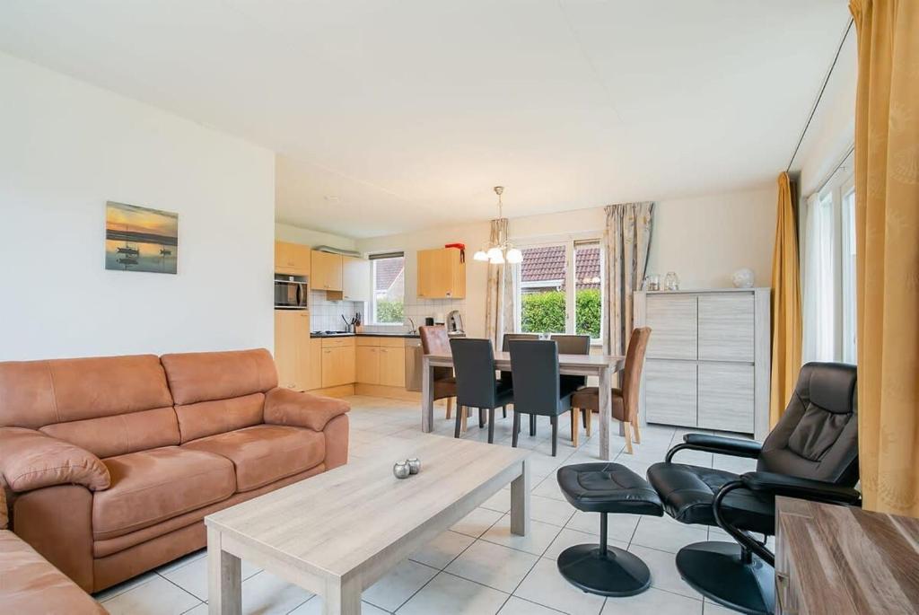 a living room with a couch and a table at Hello Zeeland - Vakantiehuis Schelde 194 in Breskens