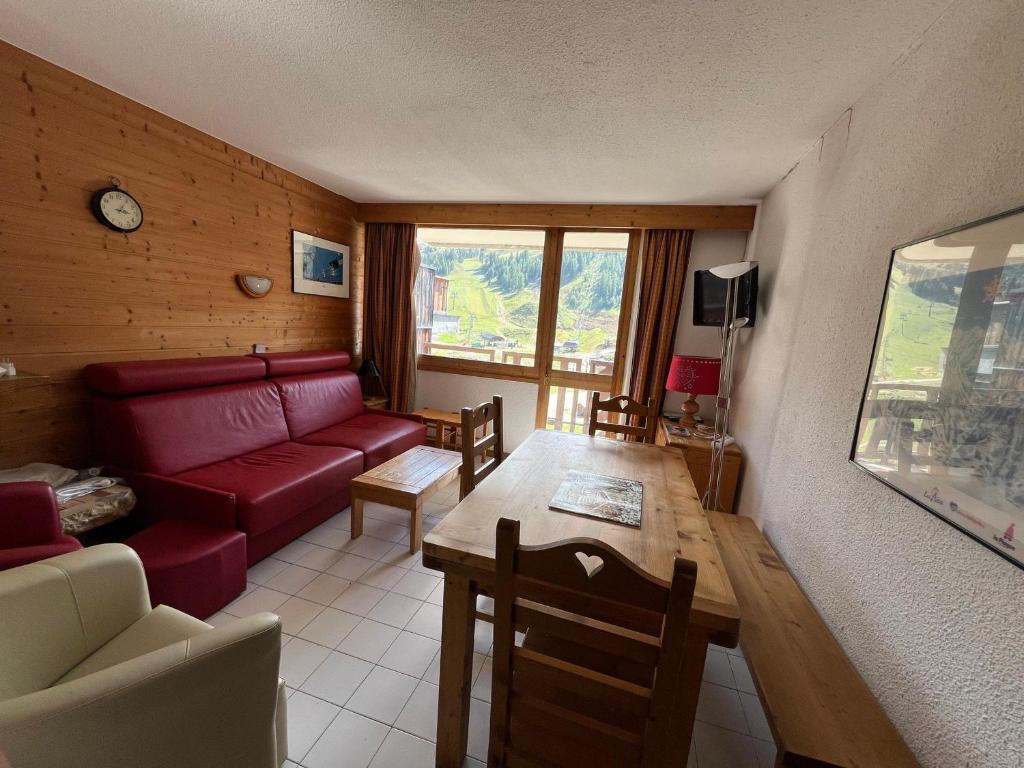un salon avec un canapé rouge et une table dans l'établissement Appartement fonctionnel, 3 pièces, balcon, 7 personnes, animaux admis - FR-1-181-2420, à La Plagne Tarentaise