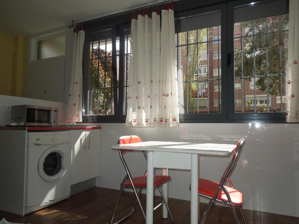 馬德里的住宿－庫瓦特羅托雷斯公寓，厨房配有桌子和洗衣机。