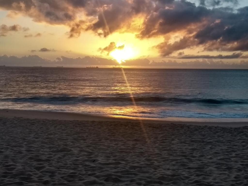a sunset on the beach with the ocean at Apartamento Praia Coqueiral de Itaparica - Vila Velha in Vila Velha