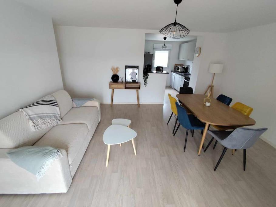 - un salon avec un canapé et une table à manger dans l'établissement Appartement proche de la mer à Pléneuf-Val-André, à Pléneuf-Val-André
