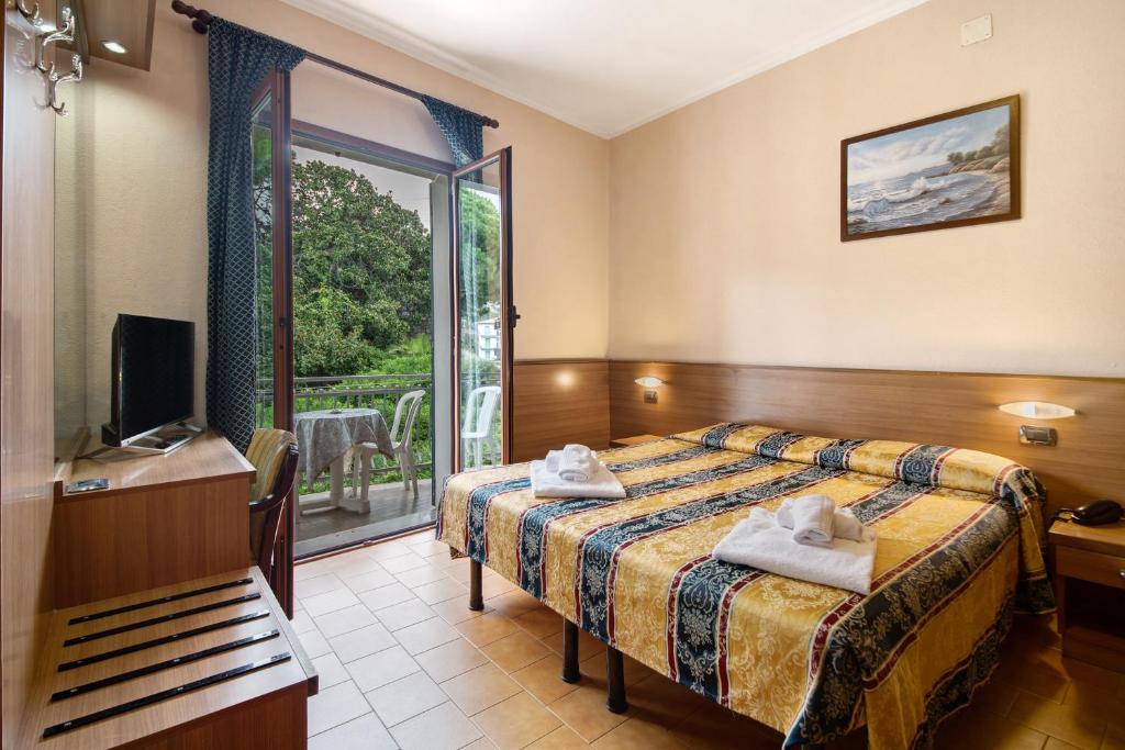 a hotel room with a bed and a balcony at Appartamento Bilocale Moneglia 21 in Moneglia