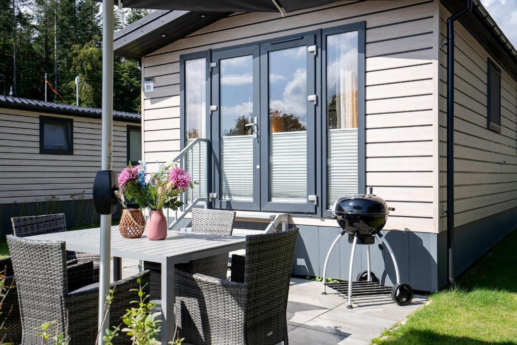 a patio with a grill and a table and chairs at Ostseecamp Ferienhaus "Pier 99" in Scharbeutz