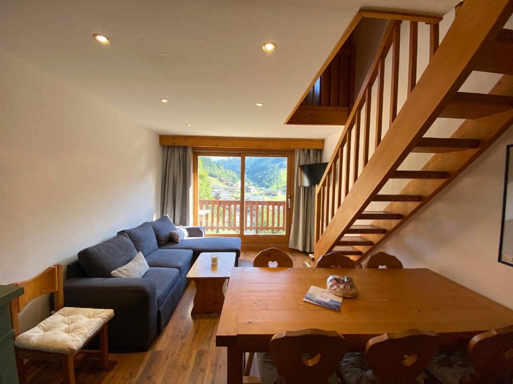 - un salon avec un canapé bleu et une table en bois dans l'établissement Duplex 3 pièces au pied des pistes, 6 pers, Méribel centre - FR-1-411-862, à Les Allues