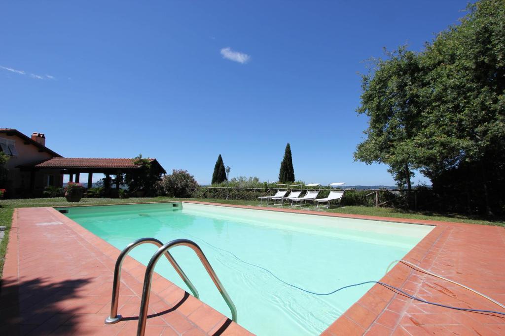 a large swimming pool with two chairs next to it at Appartamento Villa Poggio La Leona in Cerbaia