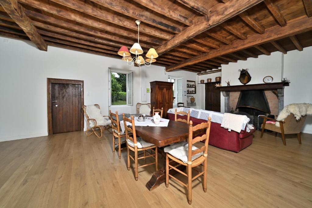 a dining room with a table and a fireplace at La maison Bayle in Mauvezin