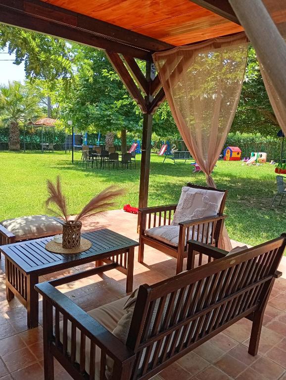 a patio with a table and chairs under a pavilion at Noufara Apartments in Nea Mesangala
