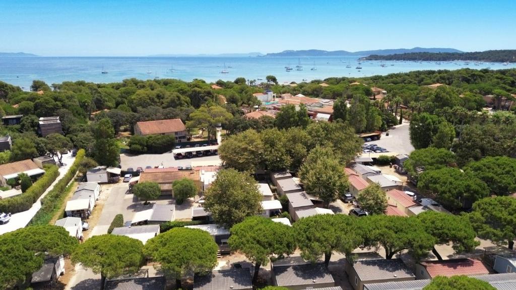 Una vista aérea de un pueblo con árboles y agua. en Camping La Bergerie Plage, en Hyères