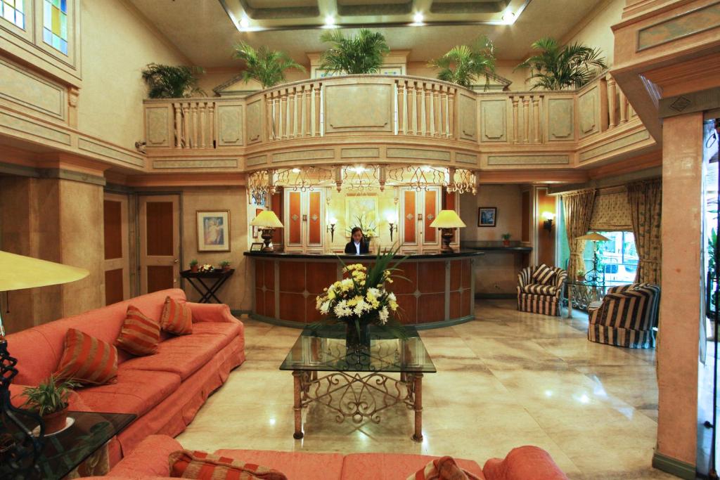 a lobby with a couch and a table with flowers at Manila Manor Hotel in Manila