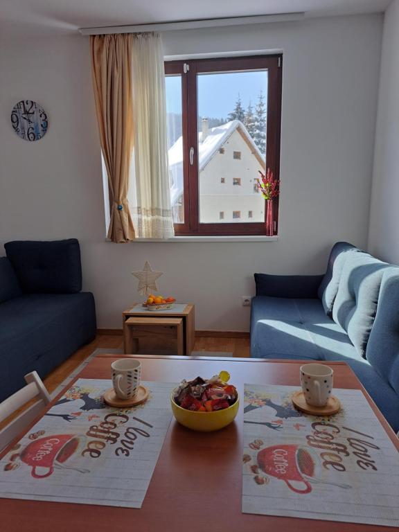 a living room with a table and a couch at Kopaonik apartman 11 in Kopaonik
