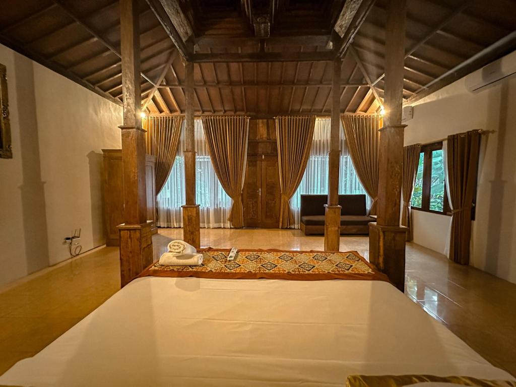 Postel nebo postele na pokoji v ubytování Kampoeng Joglo Abangan Ubud